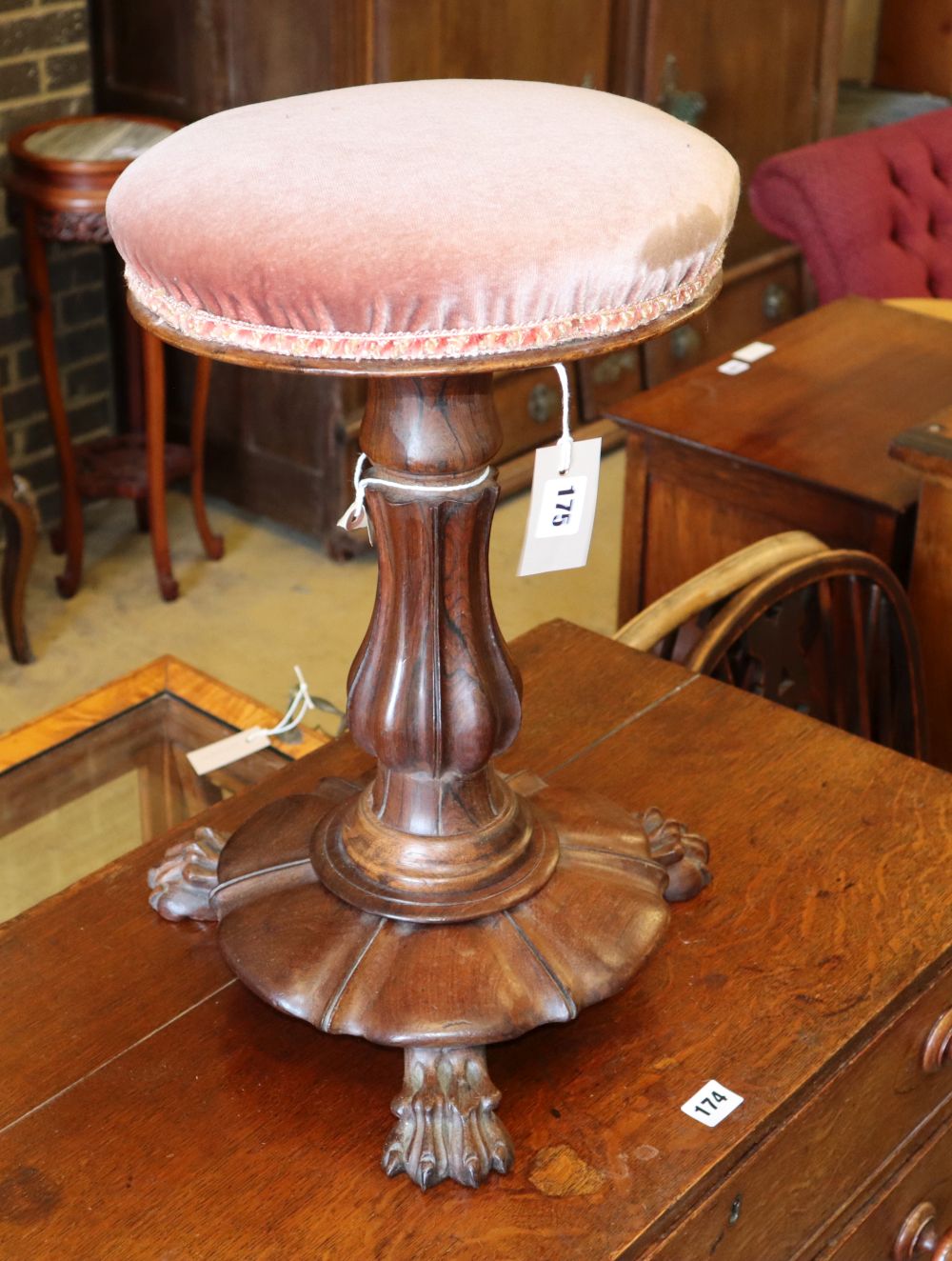 A Victorian rosewood pink upholstered revolving piano stool